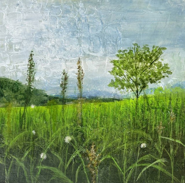 An acrylic landscape painting of a field of green grass and tall plants in the foreground. A simple small tree is back and little with a darker green hill in the background on the left. As the field moves back into the distance it becomes yellow-green struck by the sunlight. The sky is solft blue with soft white clouds. By Juanita Bellavance