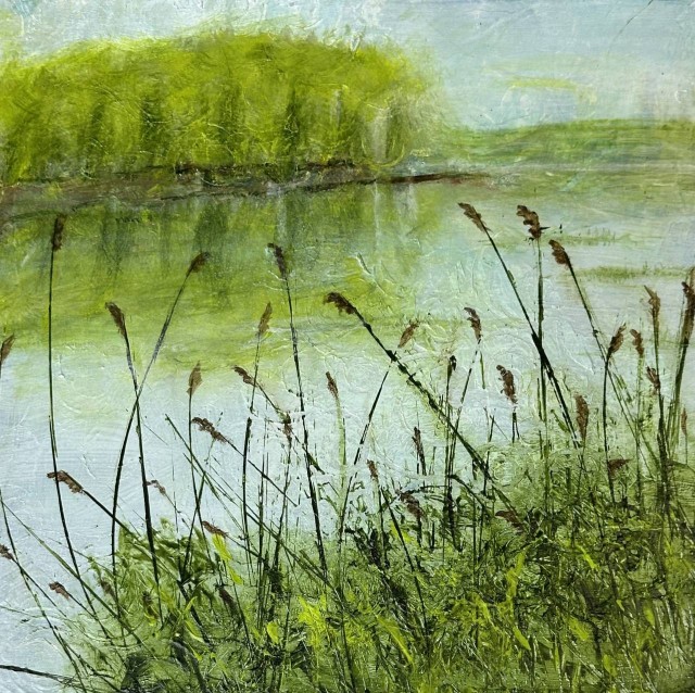 An acrylic painting of a riverscape where trees in the distance are reflected on the water white tall grasses with brown tips are growing from within the green grass in the foreground. By Juanita Bellavance